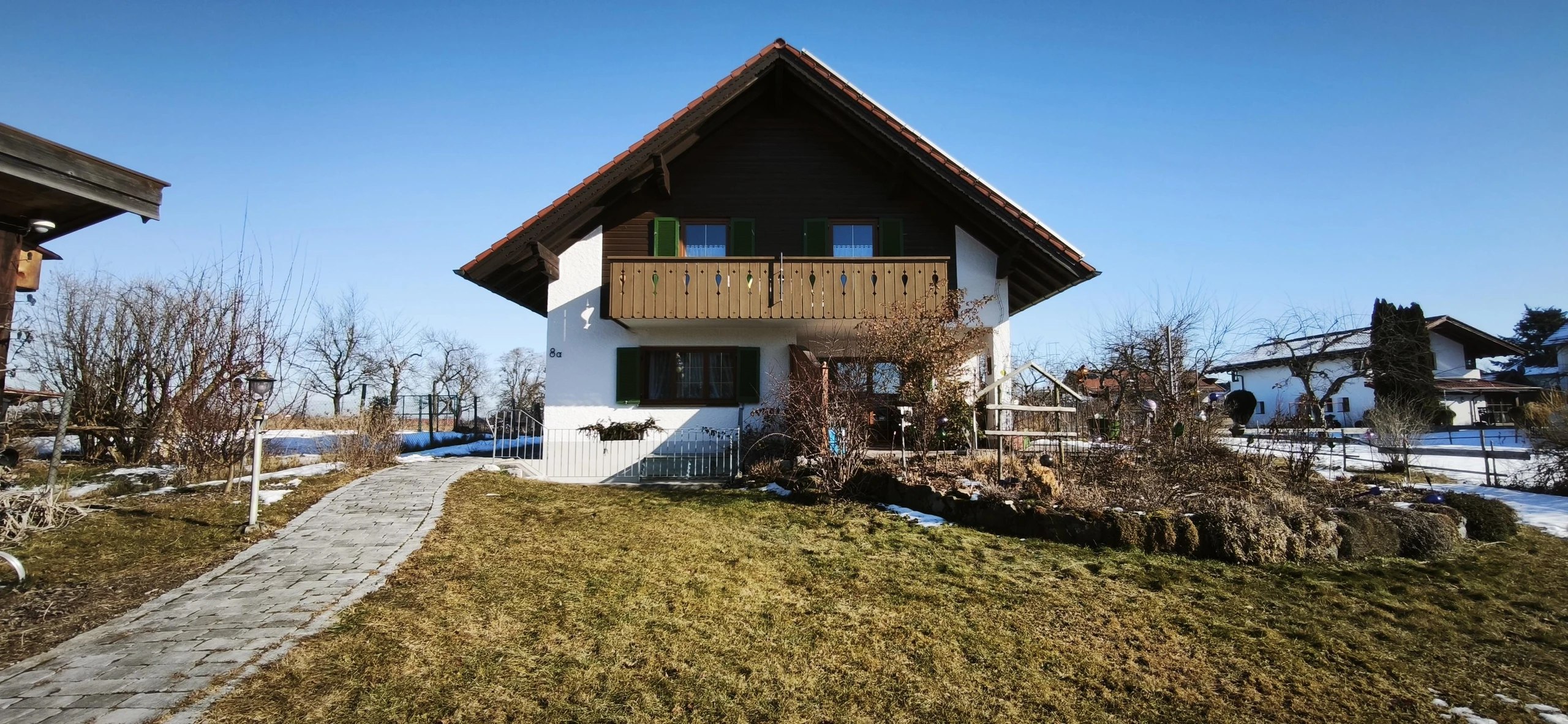 Außenansicht der Ferienwohnung Höbel in Uffing mit Garten, Balkon und freiem Blick ins Blaue Land