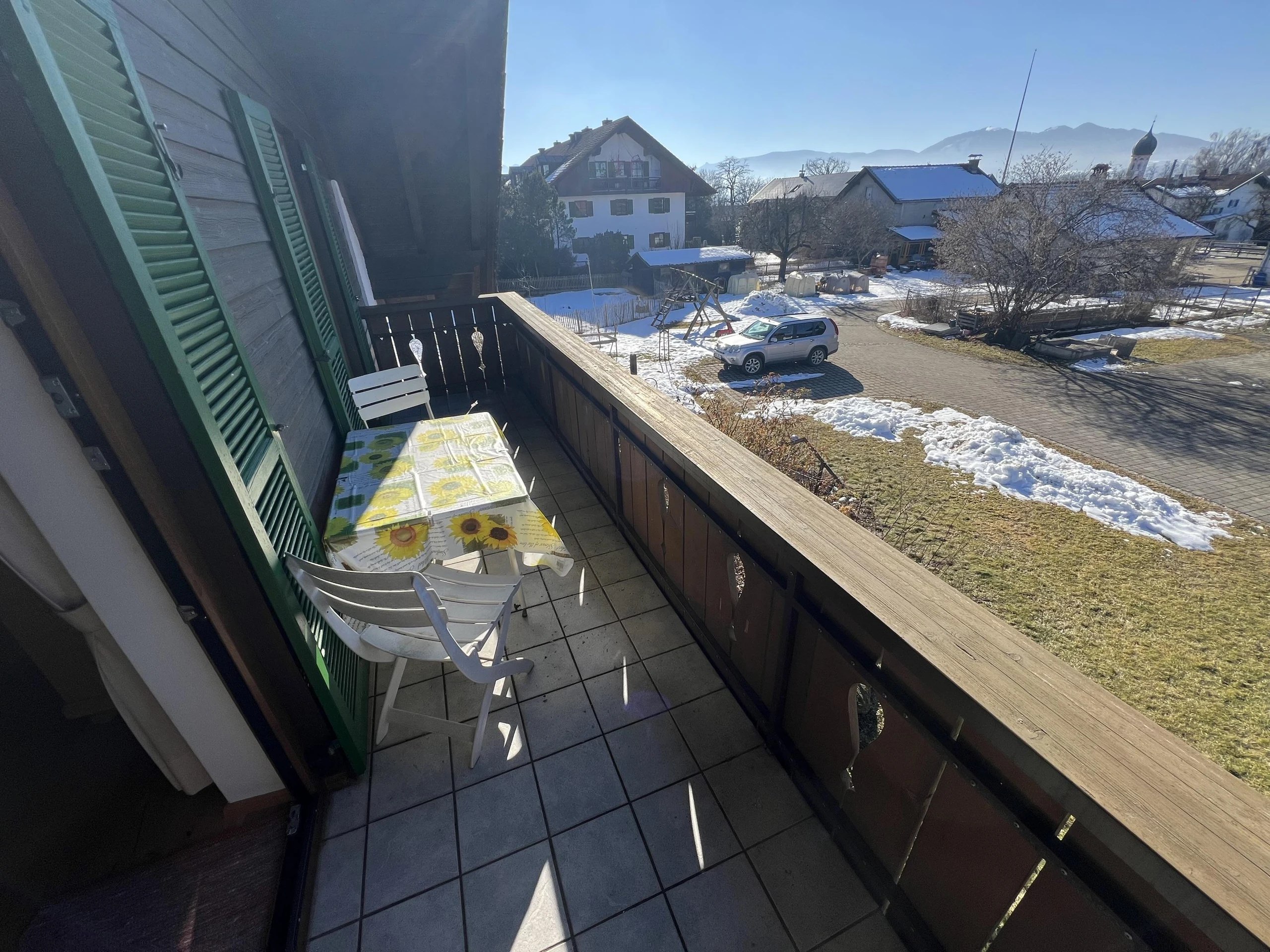 Überdachter Balkon der Ferienwohnung mit Sitzplatz und weitem Blick über Uffing und die Landschaft