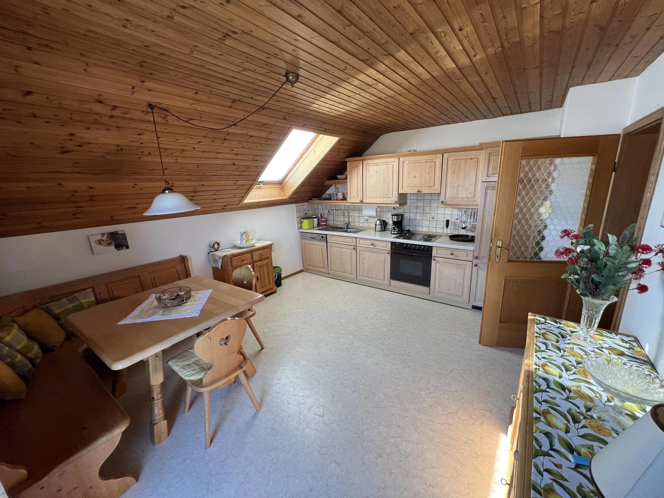 Küche und Essbereich der Ferienwohnung mit Holztisch, Küchenzeile und freundlichem Tageslicht
