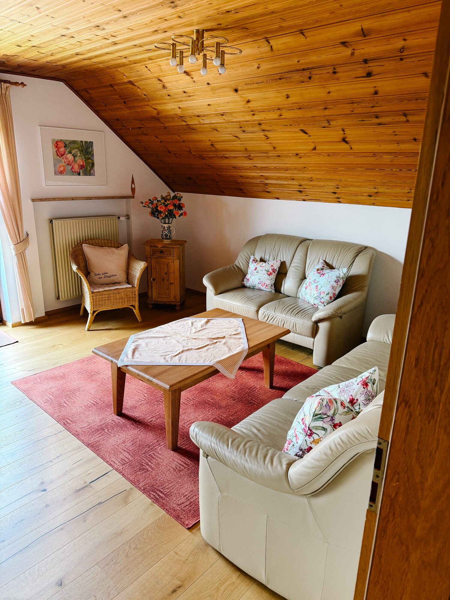 Heller Wohnbereich der Ferienwohnung Höbel mit Holzdecke, Sitzecke und bayerisch warmer Einrichtung